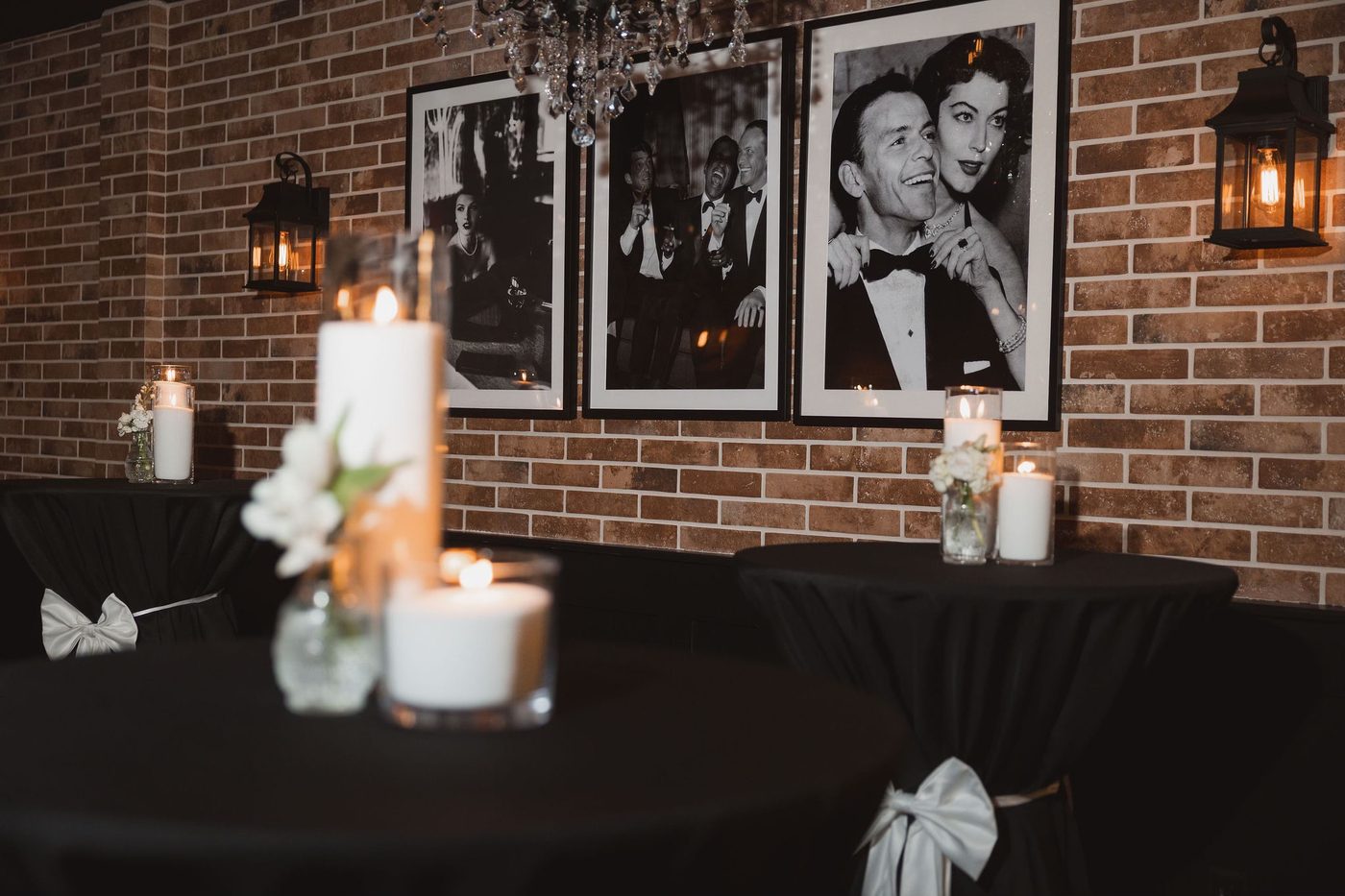 Framed black and white portraits above candlelit cocktail tables at Clarizio's.